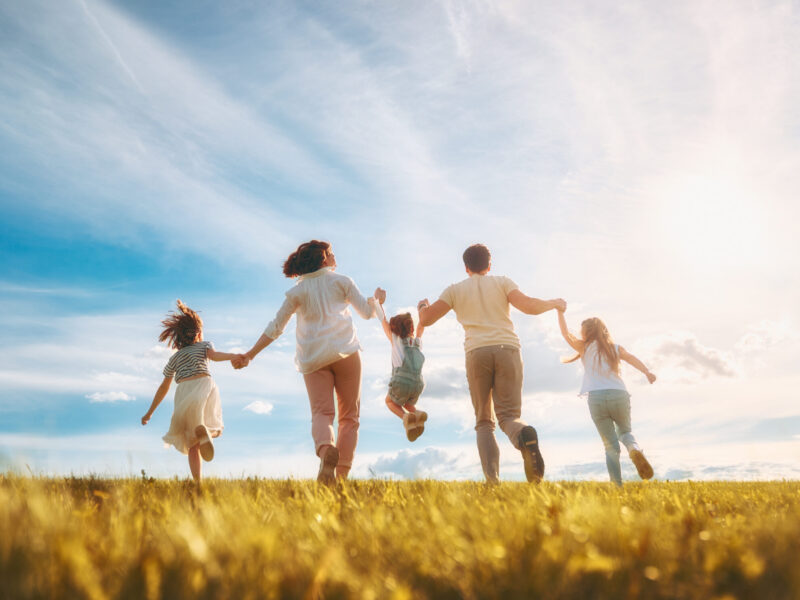 Happy family on summer walk! Mother, father and daughters walking in the Park and enjoying the beautiful nature.